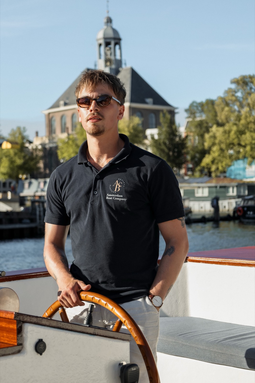 Ervaren privé kapitein aan het roer van een elektrische sloep in Amsterdam