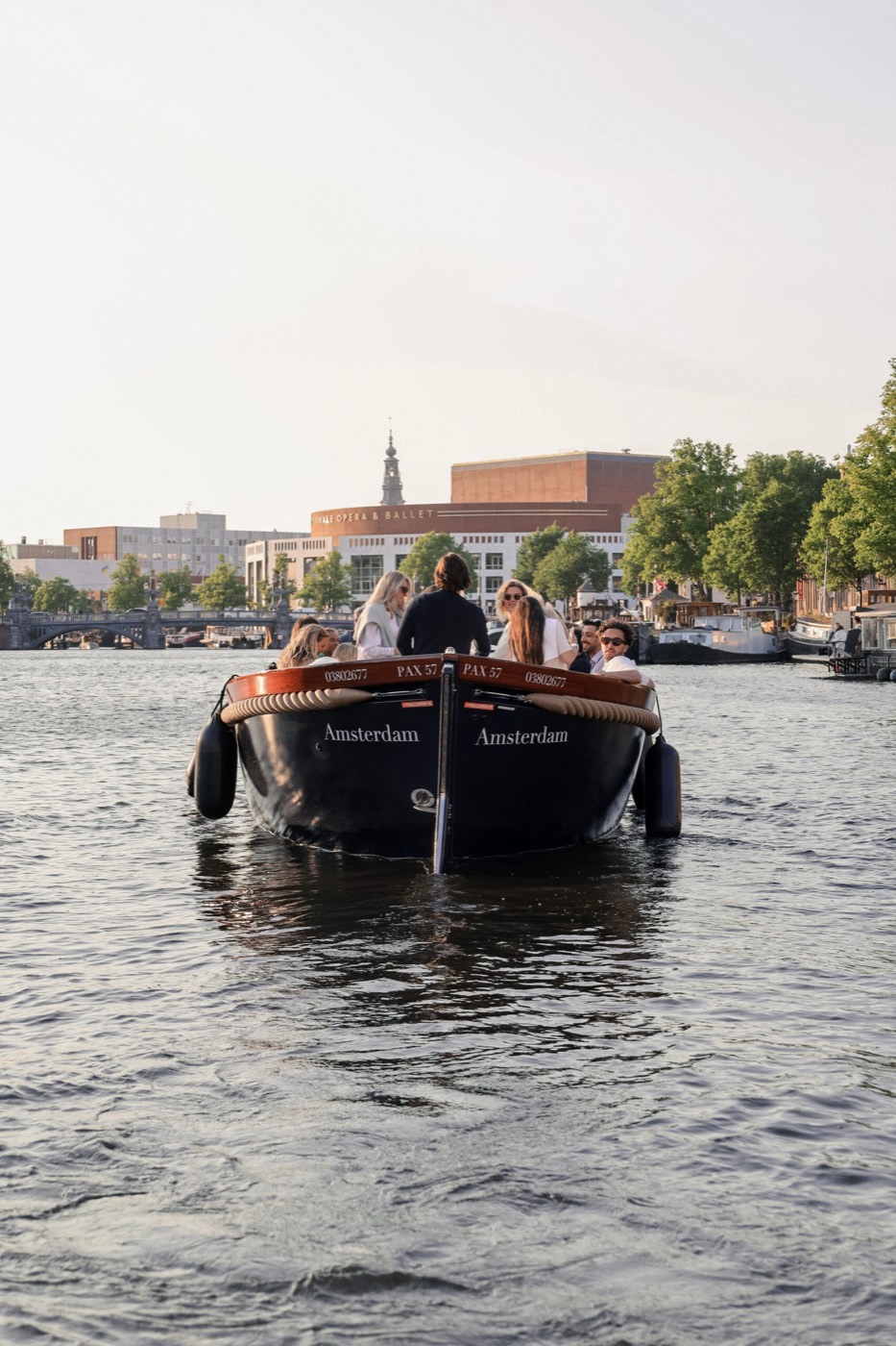 Groep gasten geniet aan boord van een privé sloep op de Amsterdamse grachten